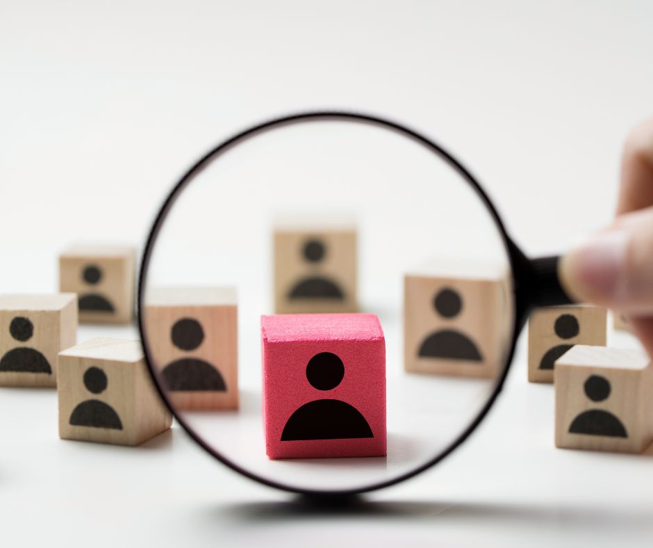 Recruitment - magnifier glass magnifying a block with a figure of a person