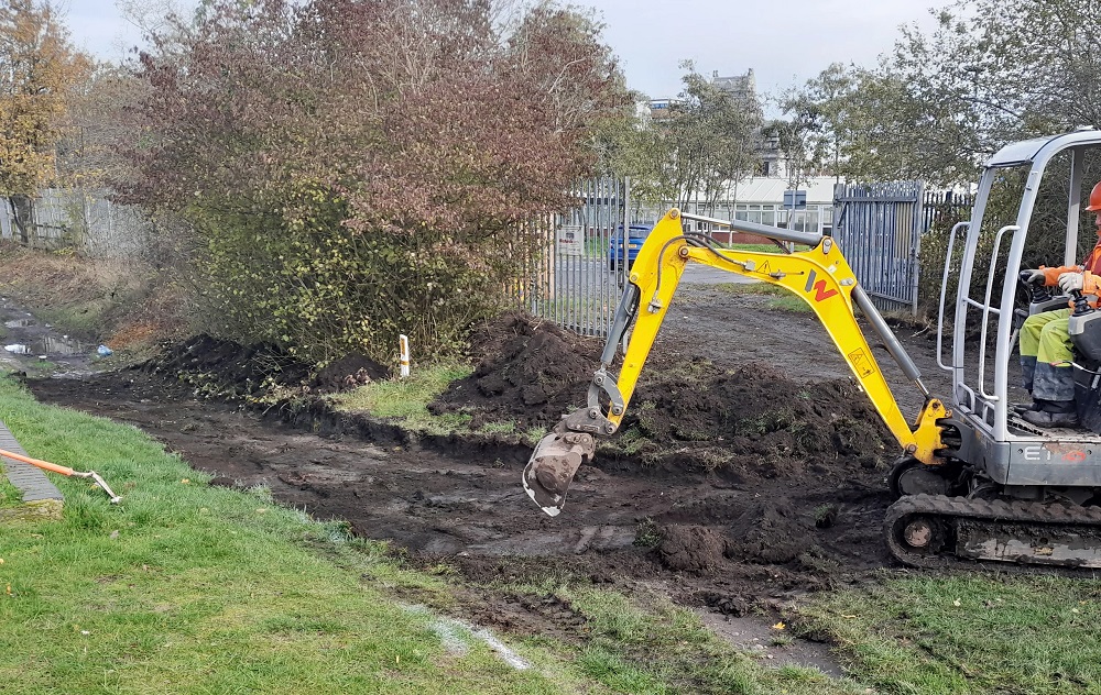 A mini digger located on the canal towpath as works commence.